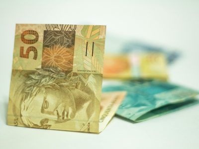 Brazilian Real banknotes in focus with 50 denomination displayed prominently.